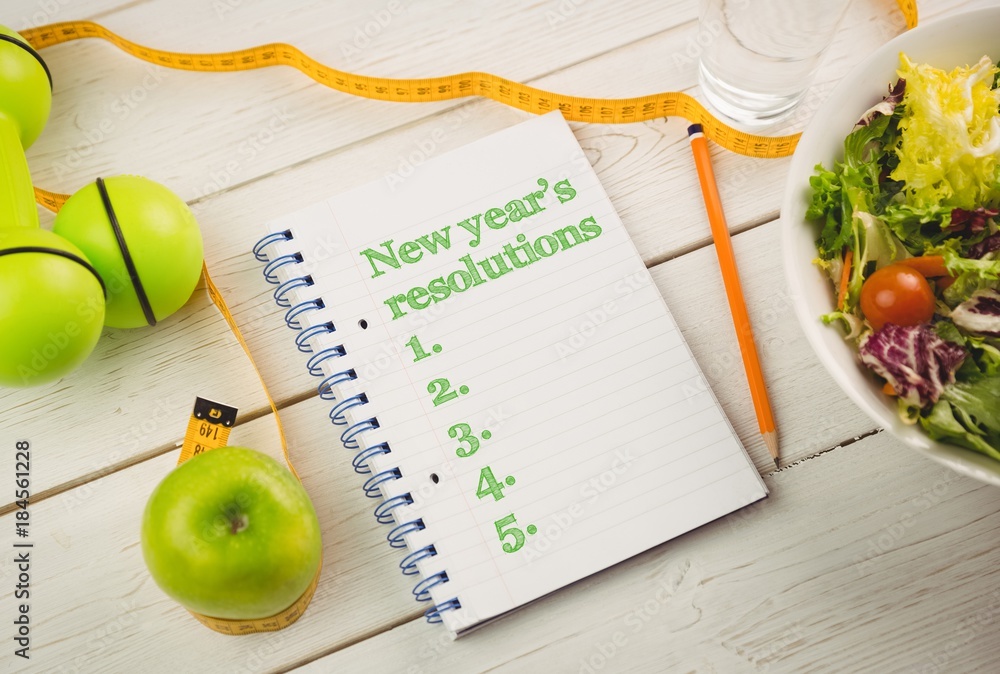 Poster top view of new years resolution written on notepad with bowl of salad and measure tape