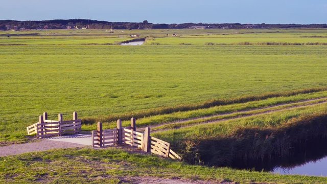 Dutch sea dike sluice gate polder drainage water outlet view towards farmland