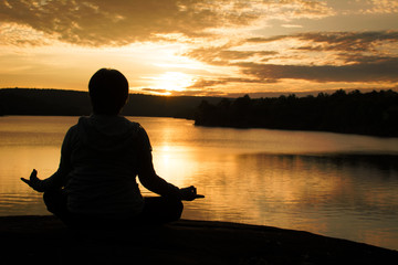 Silhouette of old woman yoga near lake during sunset, Relax time and exercise, color vintage style