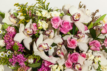 composition of flowers from pink roses, white orchids, red tulips, hyacinth and hrzemtem. Flower Arrangement in a box for a girl of roses, tulips and orchids on a white background