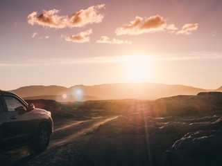 majestic landscape with car on iceland road and beautiful sunset