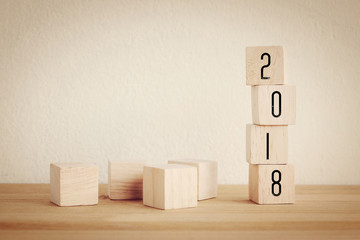 2018 new year greeting card with copy spce for text, wooden cubes with 2018 on wooden table background, new year template, vintage filtered