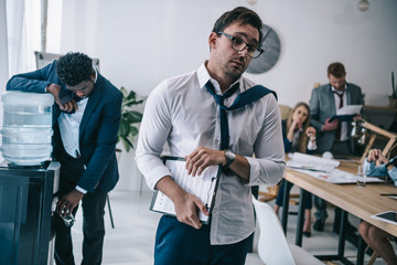 exhausted untidy businessman going out conference hall at office