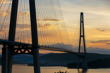 Fototapeta na wymiar Amazing zooming out aerial view of the Russky Bridge, the world's longest cable-stayed bridge, and the Russky (Russian) Island in Peter the Great Gulf in the Sea of Japan. Sunrise. Vladivostok, Russia