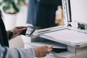 cropped shot of woman in formal wear using modern copier