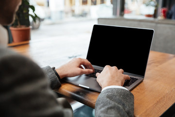 Cropped image of business man sitting by table in cafe
