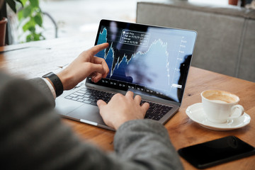 Cropped image of business man sitting by table in cafe