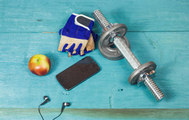 Sport items bottle, dumbbells, gloves on the sport flooring