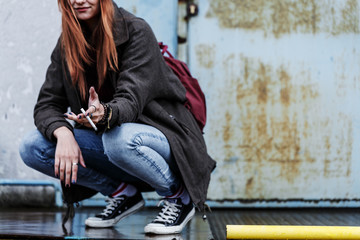 Obraz na płótnie Canvas Smiling young girl smoking cigarette
