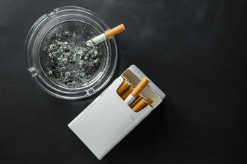 Cigarette on a dark background. Ashtray. quit Smoking