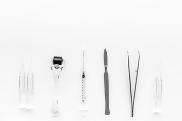 Dermatologist or cosmetologist accessories. Dermaroller, beauty injection, ampoulie, tools on white background top view copyspace