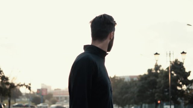 Incredible cinematic shot of man looking back. Back view slow motion. Amazing sun glare. Reflecting and thinking.