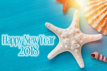 Happy New year background with shells, starfish on a wooden blue background