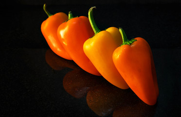 sweet peppers lined up with reflection