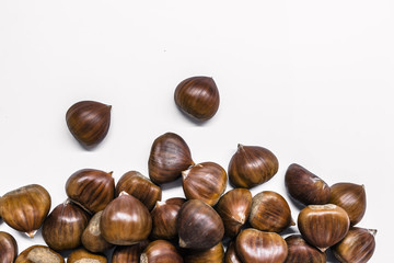 Chestnuts on a blank (white) background. Pile of fresh chestnuts ready to roast shot over white background