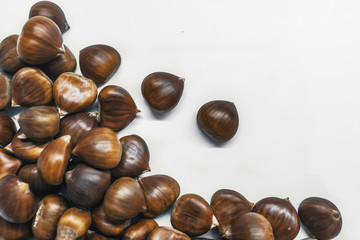Chestnuts on a blank (white) background. Pile of fresh chestnuts ready to roast shot over white background