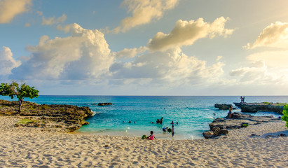Grand Cayman, Cayman Islands, Smith's Barcadere beach in the Caribbean at sunset and people in the water