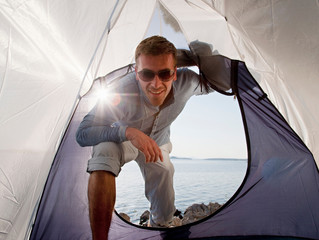 Man entering tent by sea