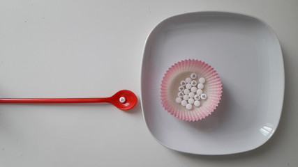 Pillole su cucchiaino rosso
