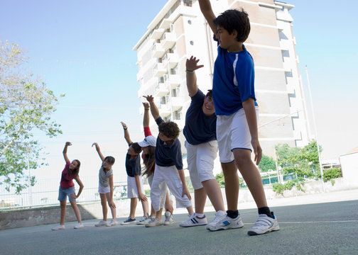 Kids on a soccaryard doing warmup