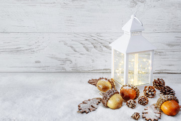 Christmas decoration. Lantern On Snow with acorns and oak leaves