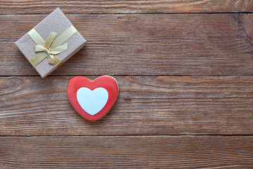 Valentine's Day. Red heart and gift box on a wooden background.