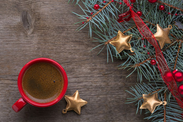  Red cup of coffee and fir branch with Christmas decorations on old wooden  background.