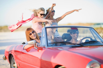 Girls with red scarf riding in cabriolet