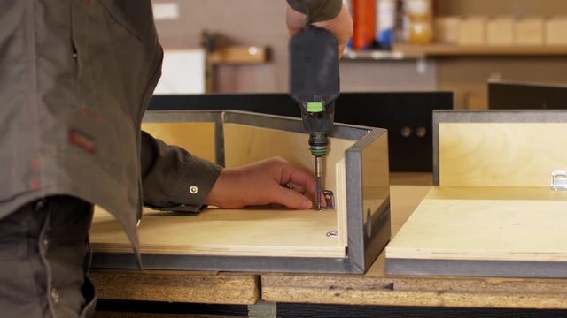 assembler with screwdriver making furniture