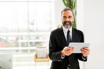 Middle age businessman with tablet in the office