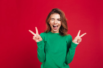 Happy young pretty woman showing peace gesture.