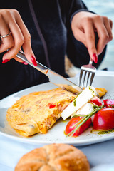 Woman eating scrambled eggs in restaurant