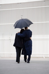 Couple walking under umbrella