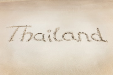 The Thailand word written on the beach sand.