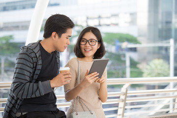 Portrait of Attractive Asian Student Pople standing at outdoor place. People holding tablet together with Education Concept.