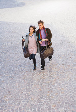 Man And Woman Arm In Arm Carrying Bags