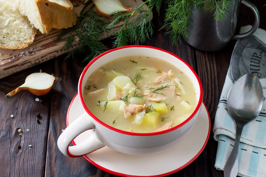 Finnish fish soup with salmon on a kitchen wooden kitchen table.