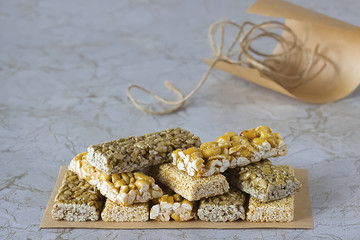 Nuts and seeds with caramel on a light marble table.