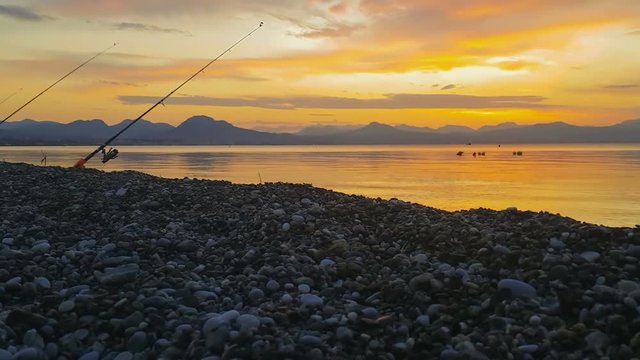 Fishing rod against a beautiful sunset at winter.
