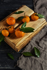 Mandarins with leaves on a wooden box.