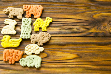 Delicious  colored zoological biscuits  for dogs with different tastes on wooden background