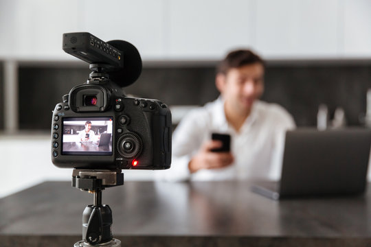 Concentrated young man filming his video blog
