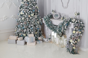 Beautiful holiday decorated room with Christmas tree and presents. White and silver christmas tree decoration. 
