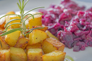 Diced fried potatoes with rosemary and red cabbage.