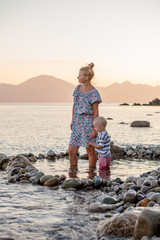 Mother and son is playing in stone pool in sea