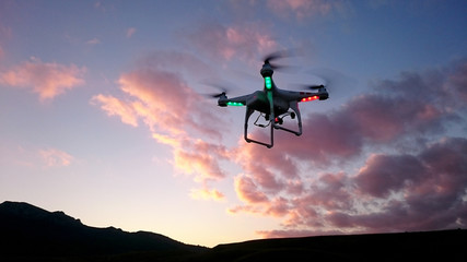 Silhouette of drone above the hills in evening skies
