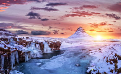 Kirkjufell mountain with frozen water falls in winter, Iceland.