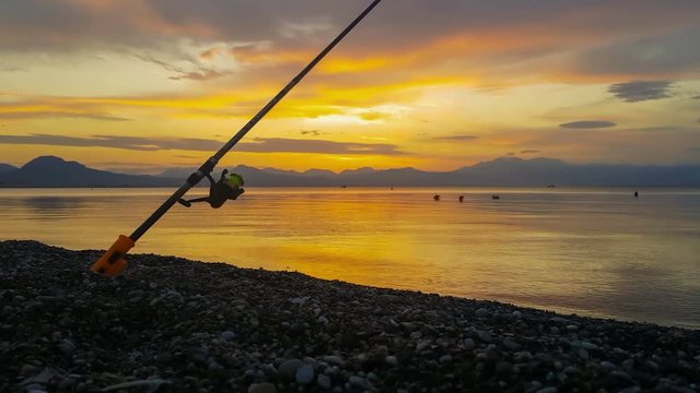 Fishing rod close up against a dramatic sunset.
