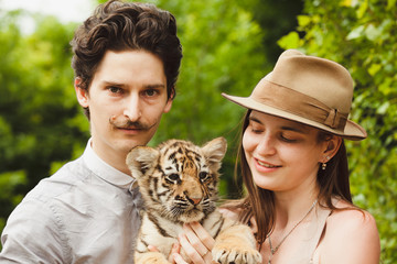 A man and woman hold tiger cub