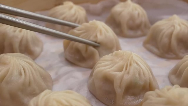 Motion of woman eating soup dumpling buns with chopsticks in restaurant in Taipei Taiwan with 4k resolution.